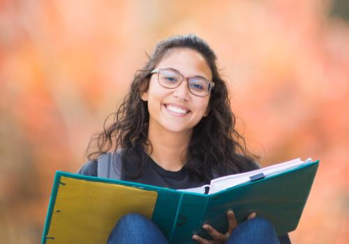 female student smiling and reading